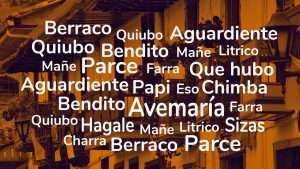lista de todas las palabras paisas que se utilizan en Medellin. El fondo es una imagen de Balcones coloridos de estilo colonial con flores y banderas en el pueblo de Salento Colombia