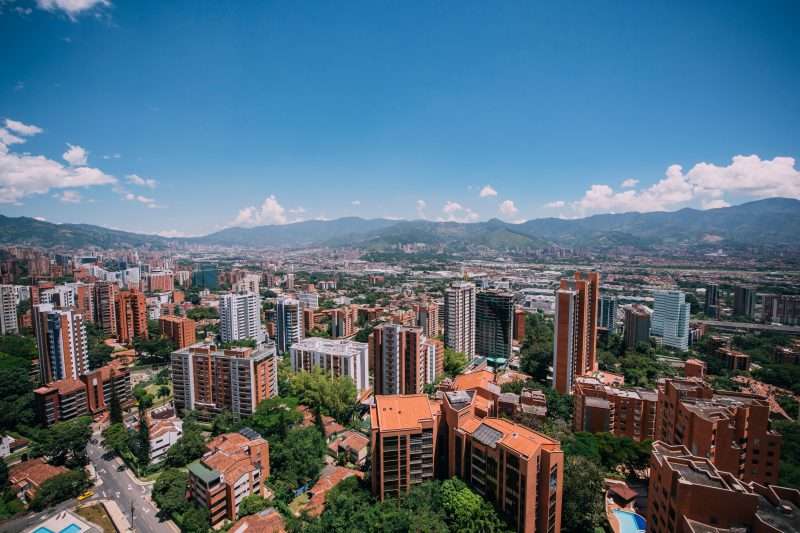 Vista aérea de los edificios y parques del barrio El Poblado en Medellín Colombia durante un día soleado.