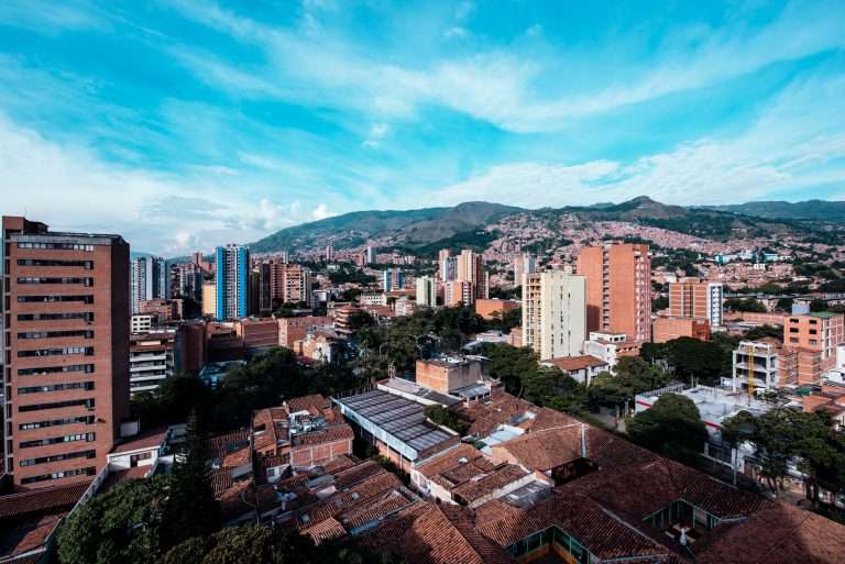 View of the urban buildings of the city of Medellin Colombia on a beautiful day with the mountains in the background.