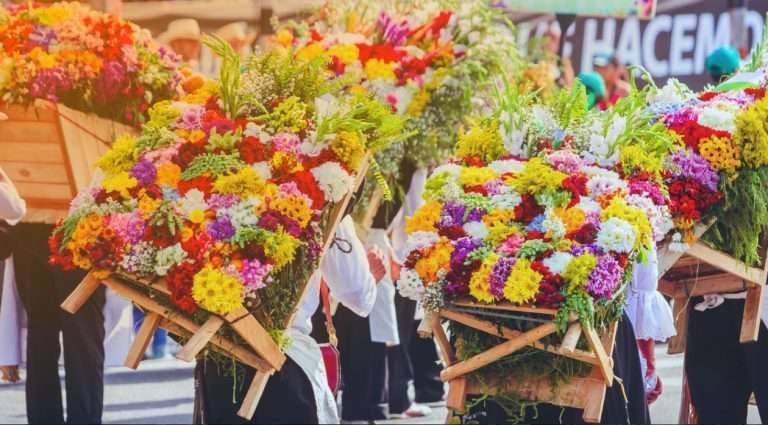 Locals of Medellín carrying colorful flowers for the Silleteros Parade during the Feria de las Flores in Medellin Colombia